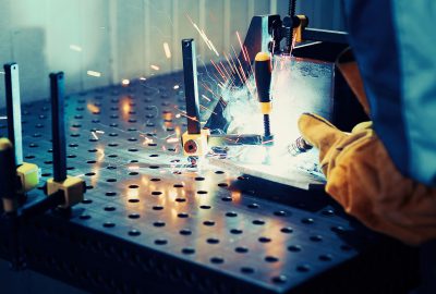 Worker welds at the factory working in metal industry